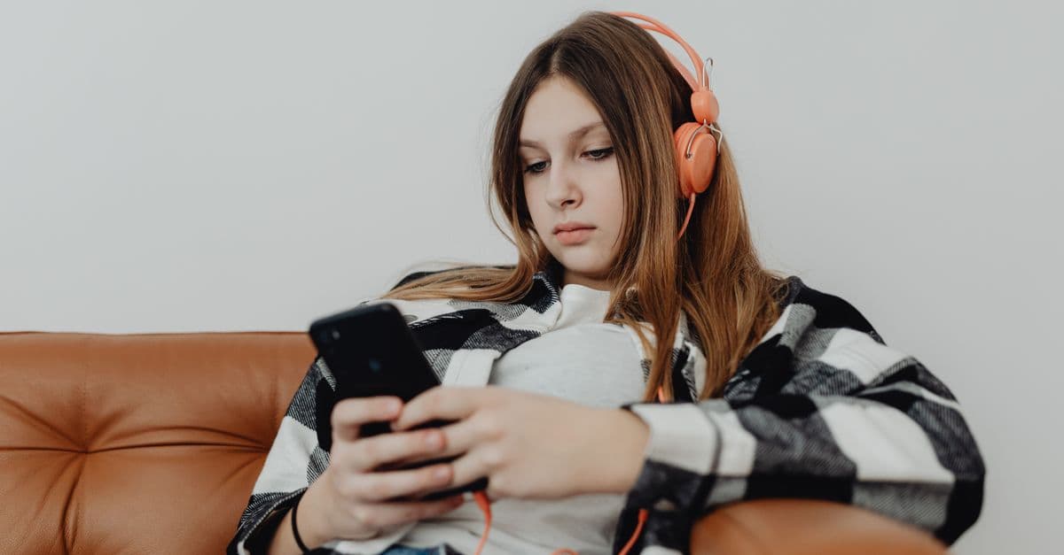 Adolescentes ouvindo música no celular — Aluno tímido que nunca participa: como a música dá o primeiro passo