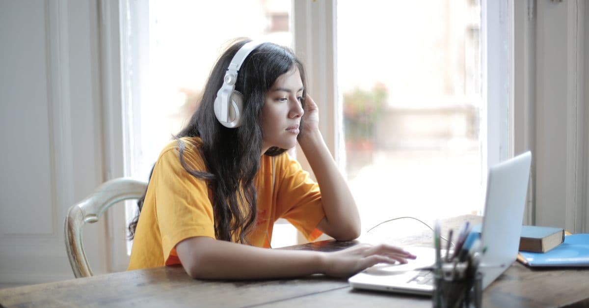 Aluna ouvindo música de fones para aprender inglês — Conectores 'But' e 'Because' com Fix You