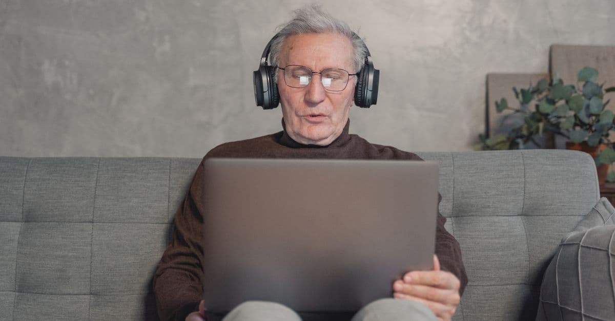 Aluno estudando inglês com fones e notebook — A1 ou A2? Como saber se uma música é fácil demais ou no nível certo