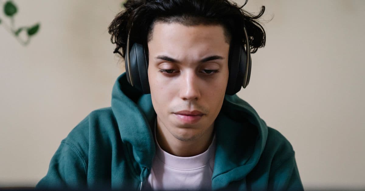 Aluno estudando inglês com fones e notebook — 3 erros que professores cometem ao usar música com alunos A1
