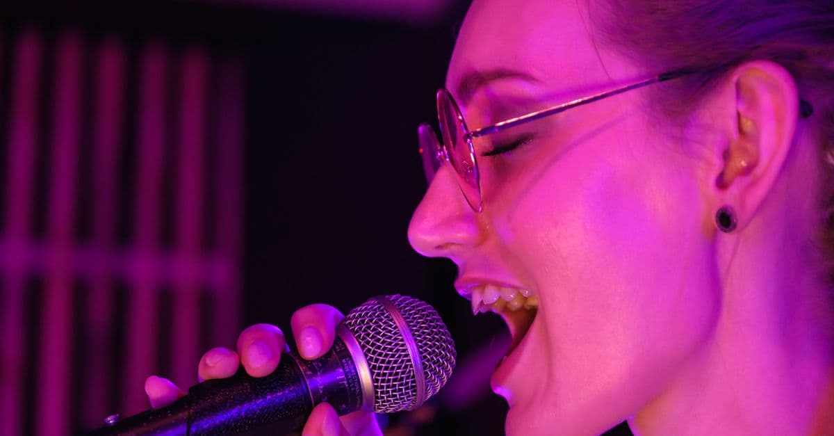 Pessoa cantando ao microfone — Hits atuais limpos: playlist sem palavrão pra usar na escola