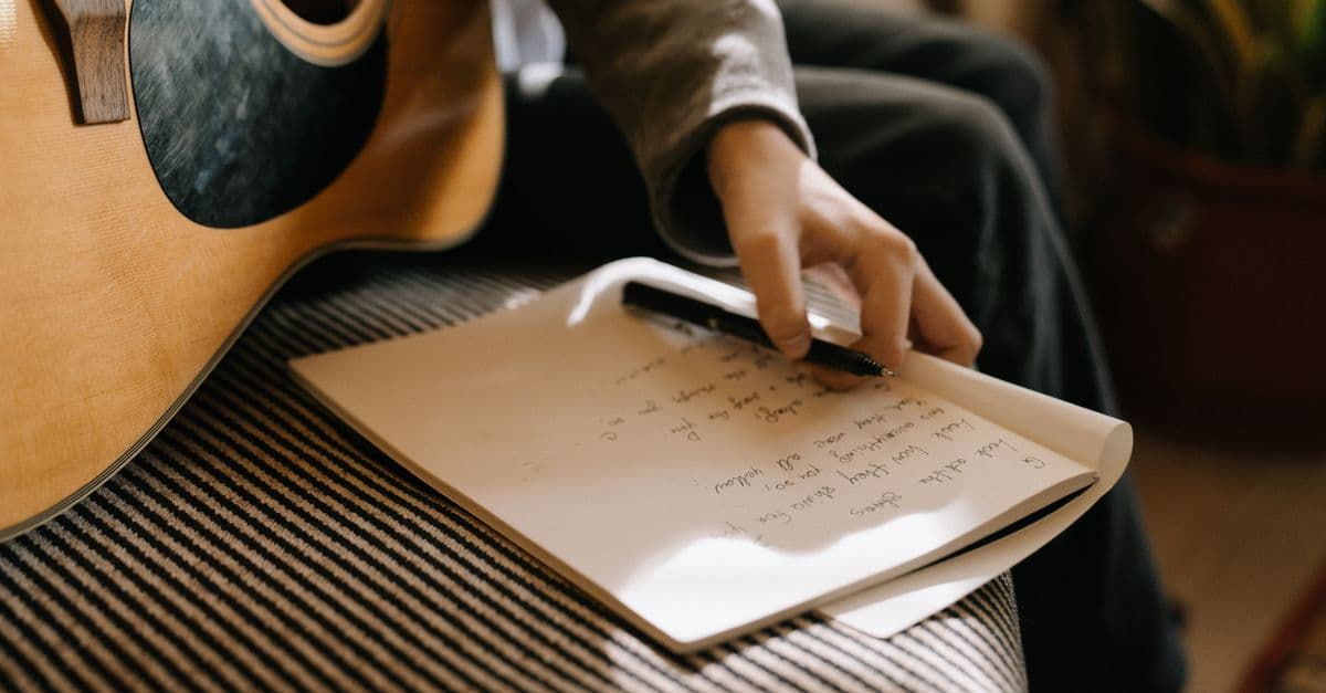 Violão e caderno de letras de música — Músicas simples pra ensinar números e dias da semana em inglês