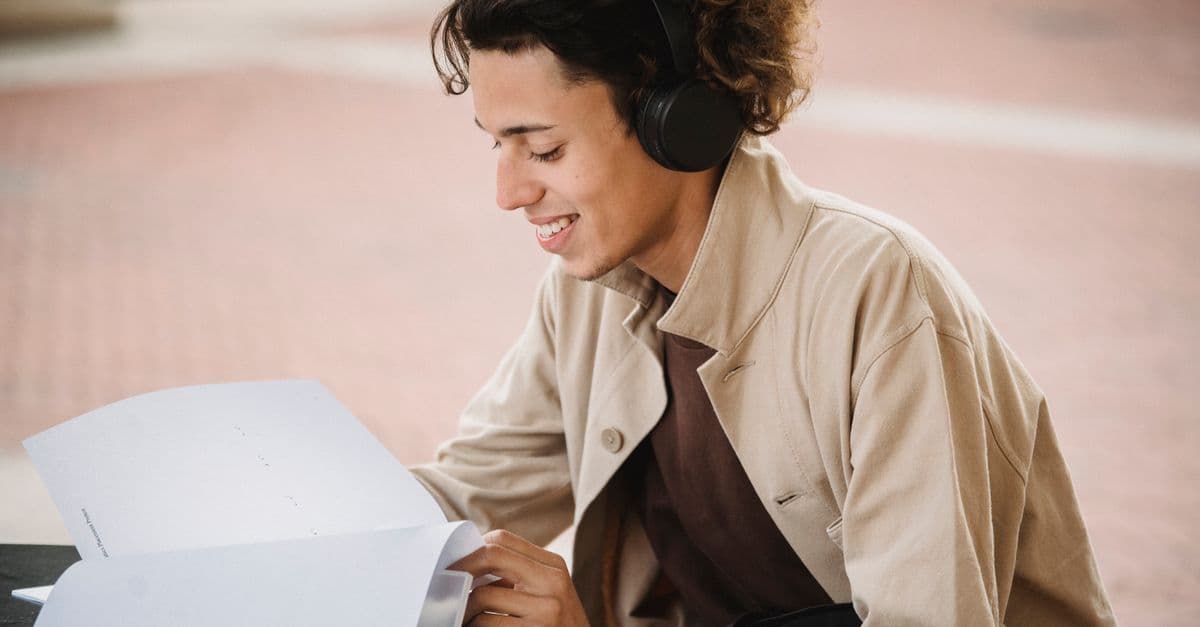 Aluna ouvindo música de fones para aprender inglês — 5 hits pop surpreendentemente acessíveis para o nível A2