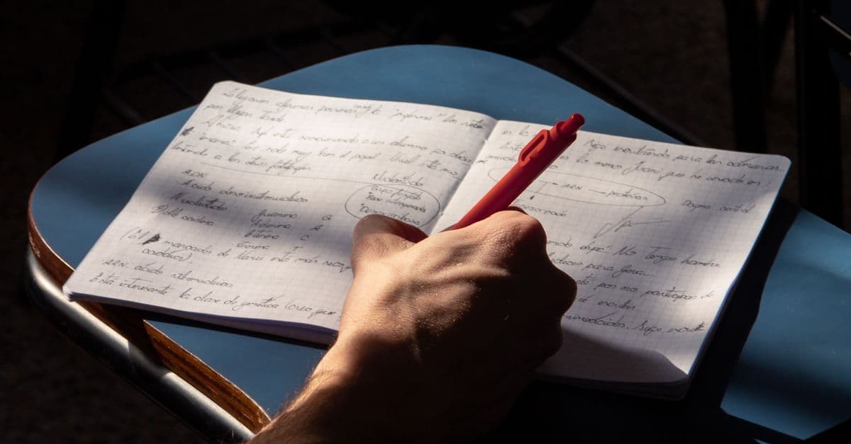 Estudante de inglês estudando com caderno — Aluno que não entende nada no listening: como a música treina o ouvido